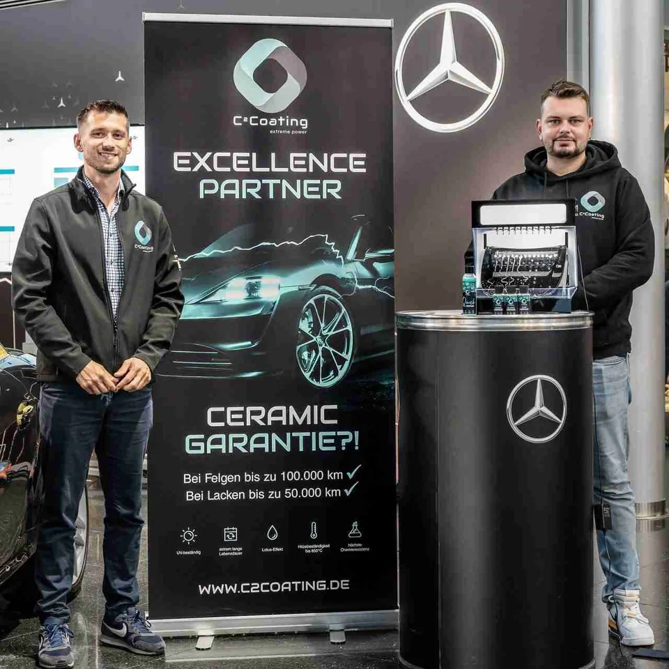 Zwei Männer mit C² Coating Banner und Mercedes Logo